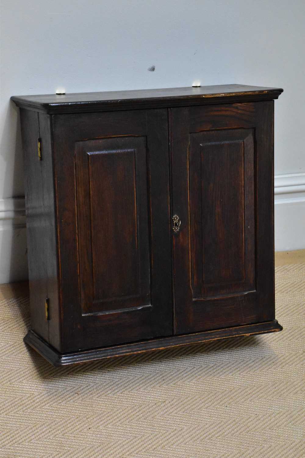 ROGER DODGSON, ULVESTON; An oak hanging cupboard, the two doors enclosing two drawers and shelves,