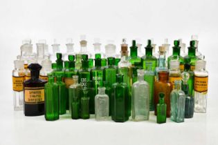 A collection of pharmaceutical glass bottles, with etched and paper labels, including green
