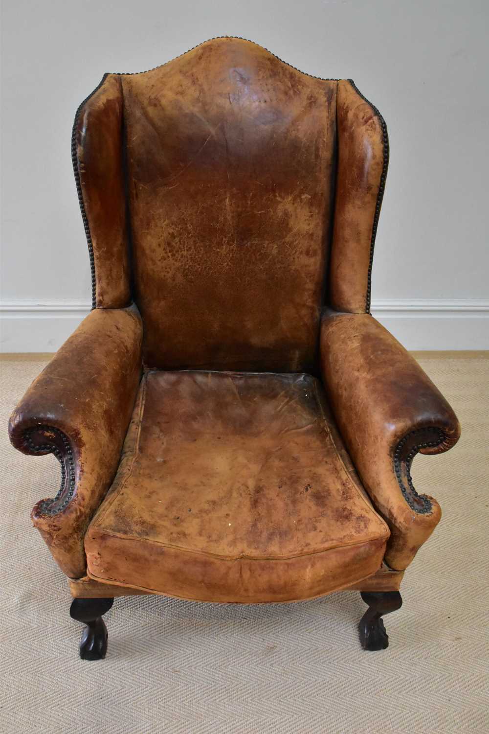 An early 20th century wingback armchair upholstered in a studded leather material, on ball and - Image 2 of 2