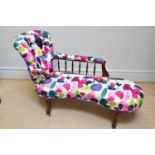 A Victorian rosewood framed chaise longue with spindle back and scrolling legs, upholstered in a