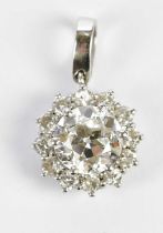 A white metal diamond flowerhead pendant, the six claw set central round cut stone weighing