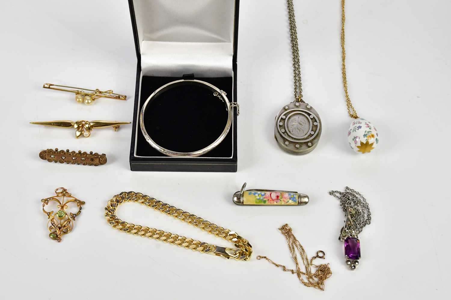 An assortment of costume jewellery including a sterling silver hinged snap bangle, a Victorian