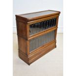 GLOBE WERNICKE; an oak two tier metal bound stacking bookcase with leaded glazed up and over door,