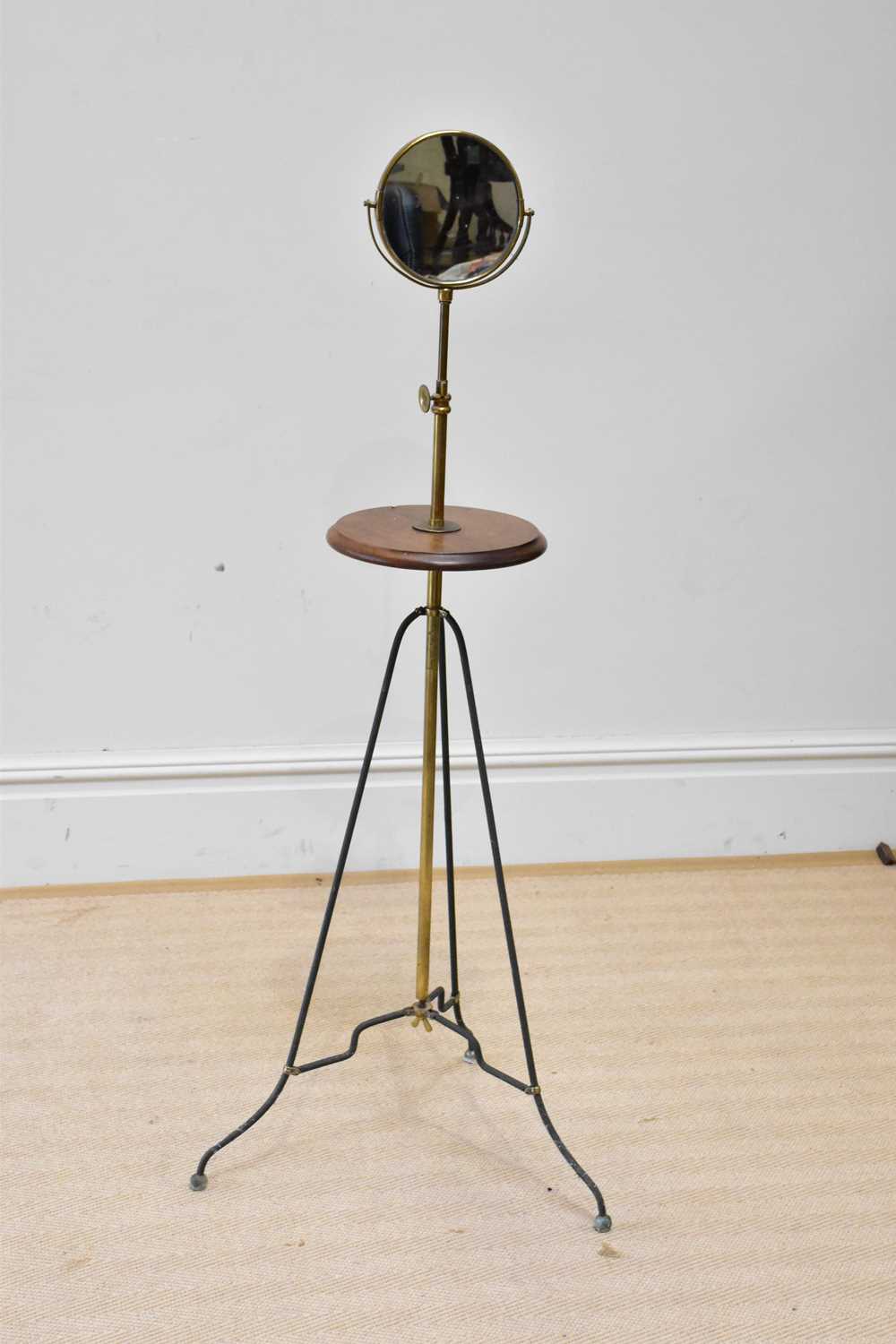 An early 20th century adjustable shaving stand with candle bracket above circular mahogany top, on