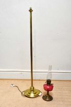 A brass standard lamp together with a brass oil lamp with cranberry glass reservoir, height of