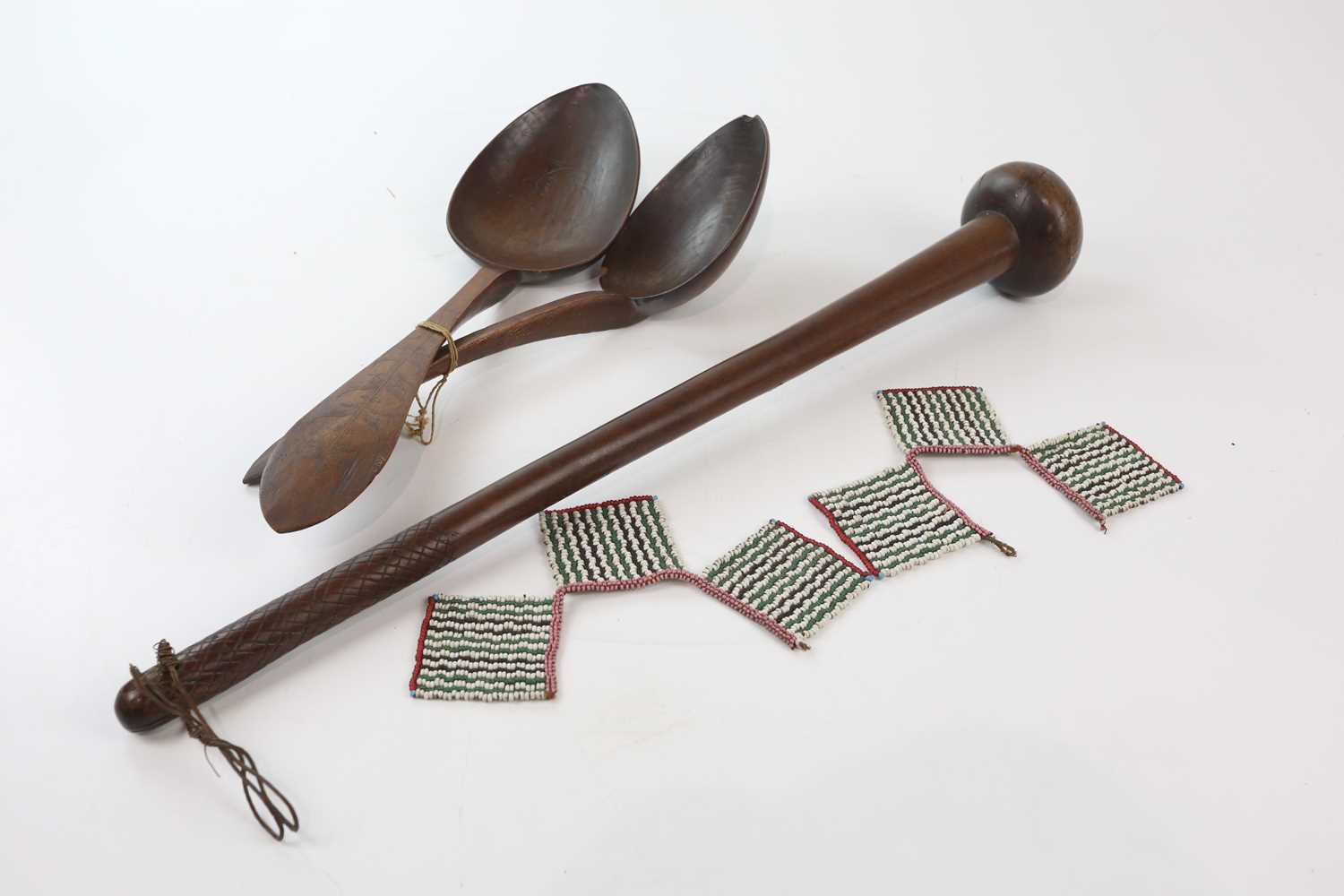 An African carved hardwood knobkerrie, length 62cm, with two carved softwood oversized spoons,