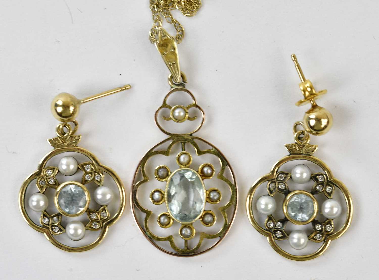 An Edwardian yellow metal pendant set with seed pearls and pale blue central stone suspended on a