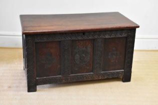 An 18th century and later oak coffer with replacement top and carved and panelled front, on block