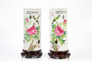 A pair of Chinese Famille Rose sleeve vases painted with exotic birds and floral sprays on