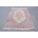 A Super Keshan rug with floral decoration on a salmon pink ground, 240 x 170cm.