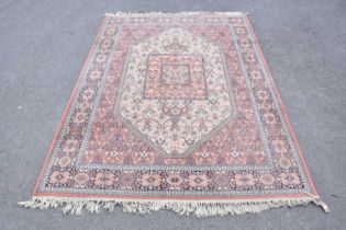 A Super Keshan rug with floral decoration on a salmon pink ground, 240 x 170cm.