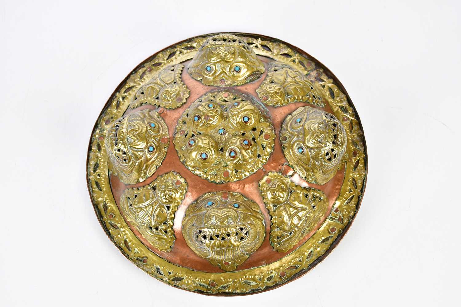 An Eastern copper and brass dahl type shield with stylised mask heads and turquoise set eyes, - Bild 2 aus 5