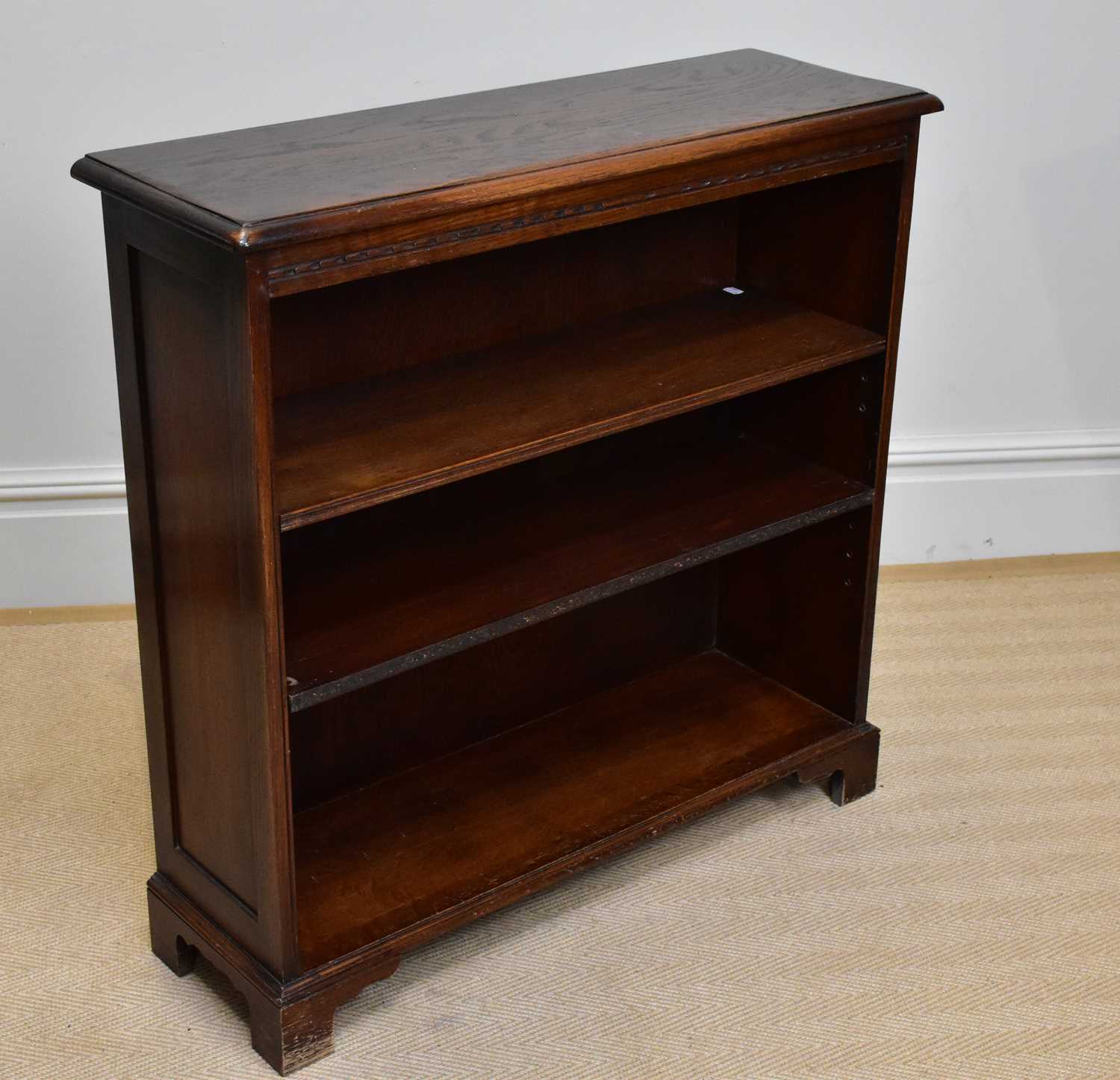 A reproduction oak freestanding bookcase with two adjustable shelves, on bracket feet, width 90cm,