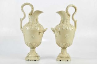 PETER WELDON; a pair of crackle glazed ewers, relief decorated with shells and floral detail, height