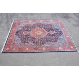 A red ground wool carpet with central geometric design, 330 x 245cm.
