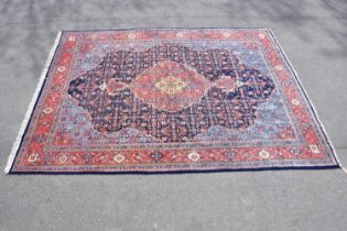 A red ground wool carpet with central geometric design, 330 x 245cm.