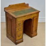 An early 20th century oak desk with raised back above the fall front, with tooled leather top