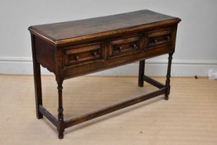 An 18th century style oak dresser base with three drawers, on bun feet, width 133cm, depth 47cm,