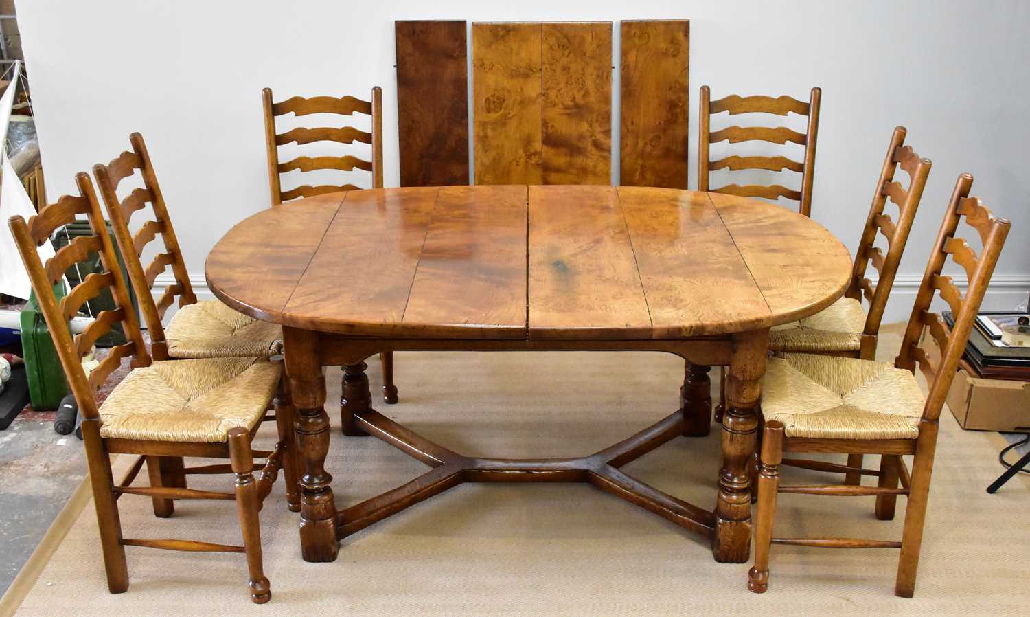 A good quality reproduction burr oak extendable dining table with three additional leaves on block