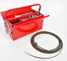 A modern red tool box containing a selection of tools and copper wire.
