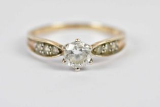 A yellow metal dress ring stamped 375 set with a central glass stone and similar glass stones to the