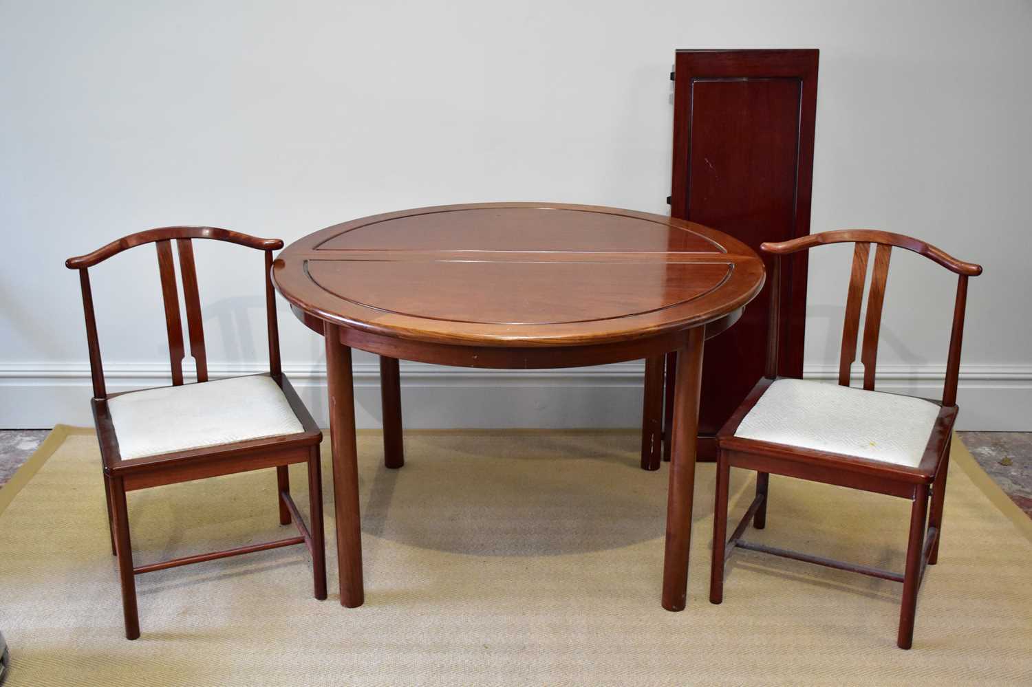 A Chinese rosewood dining table with three additional leaves, on column supports, and eight chairs.