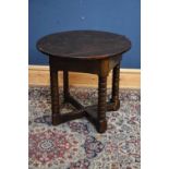 A James I oak credence table with an oval flat top and triangular frieze on bobbin turned legs