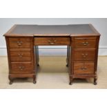 A late 19th century inverted breakfront kneehole desk with leather inset top above an arrangement of