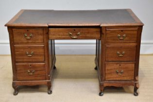 A late 19th century inverted breakfront kneehole desk with leather inset top above an arrangement of