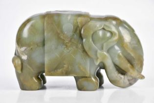 A Chinese Jade elephant, with carved decoration of auspicious symbols, height 13cm, length 19cm.