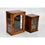An early 20th century oak smoker's cabinet with single glazed door containing two pipes and an oak