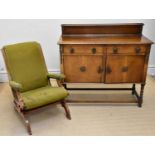 An early 20th century oak sideboard, with two drawers above two panelled cupboard doors, on bun