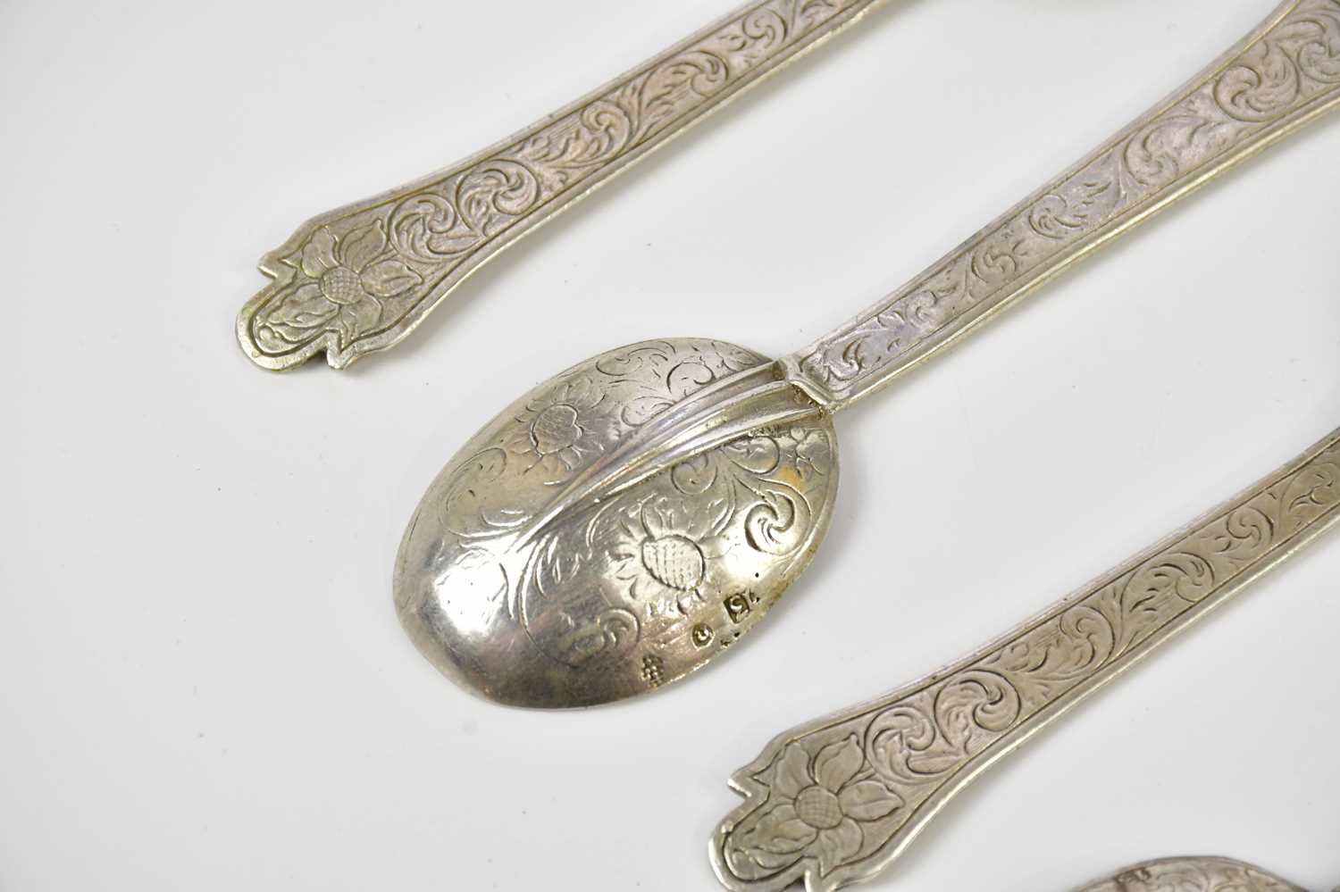 Five Continental white metal rat tail spoons, with chased scrolling decoration, indistinctly stamped - Image 5 of 6