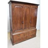 A George III oak livery cupboard, with two panelled doors enclosing hanging rail, above five