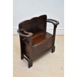 An early 20th century oak settle/stick stand with hinged seat, width 82cm.