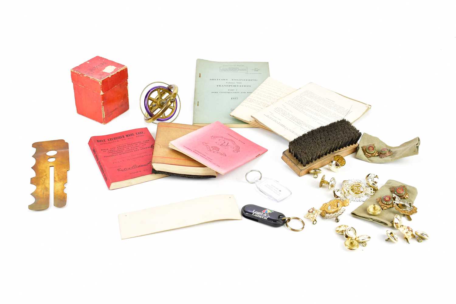 A collection of military cap badges, ephemera and a boxed gyroscope.