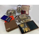 A collection of electroplated items to include a bacon warmer, a spirit kettle, cased cutlery, a