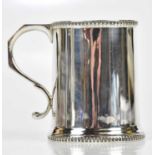 A George V hallmarked silver christening mug, with decorated rims, maker’s mark rubbed, probably
