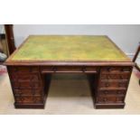 A Victorian mahogany partners' desk, with green tooled leather inset top above and arrangement of