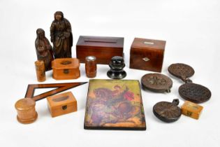 A collection of treen items to include two carved oak figures, four carved oak biscuit stamps,