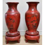 A pair of large and impressive Chinese red lacquered floor vases on stands, each decorated with