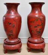 A pair of large and impressive Chinese red lacquered floor vases on stands, each decorated with