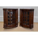 A pair of carved oak hanging bowfront corner cabinets of small proportions, height 55cm.