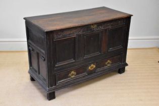 A late 17th century carved oak mule chest with panelled front above two base drawers, dated 1696,