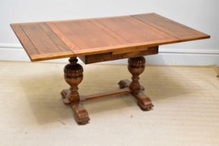An Edwardian golden oak extending dining table, on baluster legs, size closed height 75cm, width