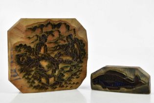 Two wood printing blocks, one of fish, the other of couple having a picnic, largest 22 x 24cm.