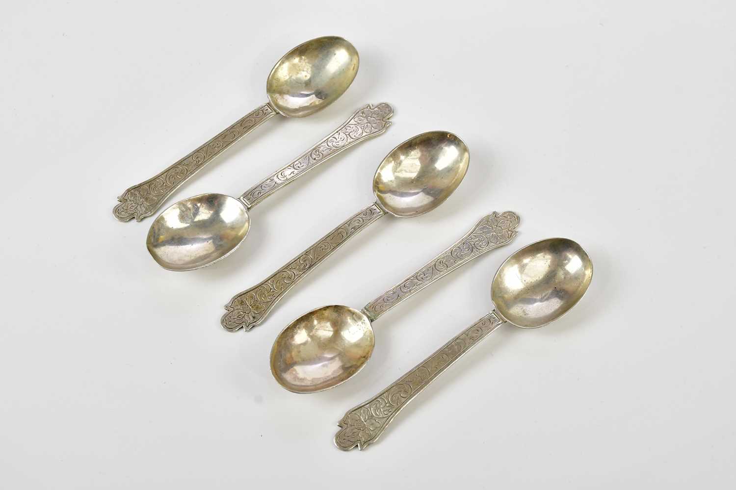 Five Continental white metal rat tail spoons, with chased scrolling decoration, indistinctly stamped