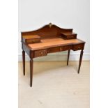 A reproduction French style writing table with raised back and tooled leather top with an