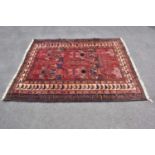 A red ground wool carpet with geometric pattern, 240 x 190cm.