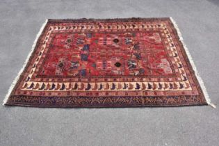 A red ground wool carpet with geometric pattern, 240 x 190cm.